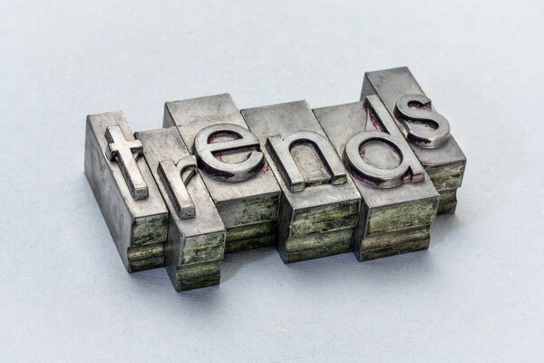 trends word abstract in grunge letterpress metal type against textured paper, business or finance concept