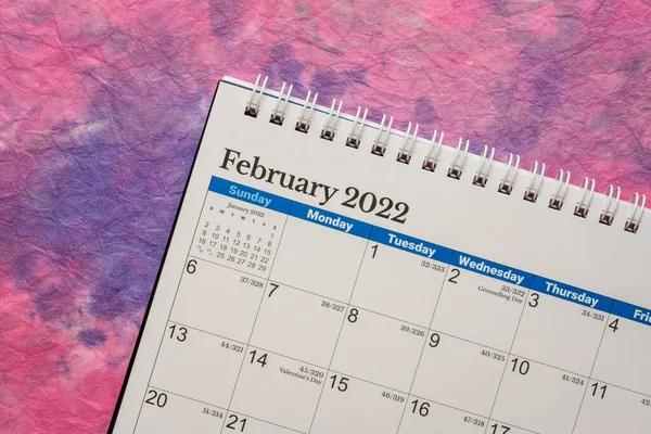 Φεβρουάριος 2022 Σπειροειδές Ημερολόγιο Επιφάνεια Εργασίας Κατά Πολύχρωμο Μαρμαροειδές Χαρτί — Φωτογραφία Αρχείου