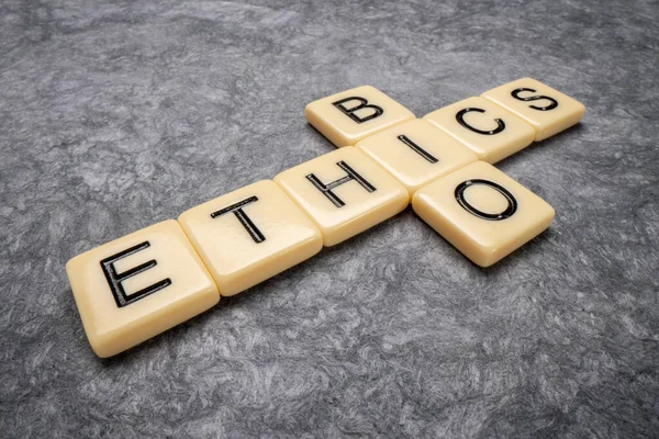 bioethics crossword in tile letters against gray handmade paper, ethics, medical, biological and biotechnology research concept