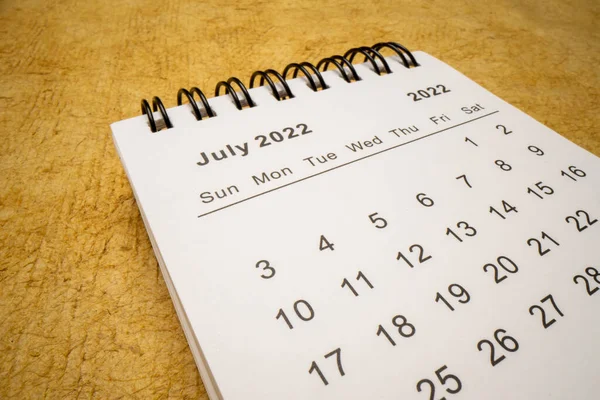 July 2022 Spiral Desktop Calendar Yellow Handmade Paper Low Angle — 스톡 사진