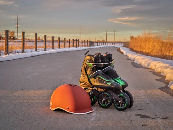 ラブランド アメリカ 2022年1月17日 冬のコンディションでウェットバイクトレイルでスケートした後の日没時に汚れたインラインスケート Mod 110 Speed Race と千の保護ヘルメットのペア — ストック写真