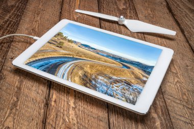 Colorado eteklerindeki su saptırma hendeği, Charles Hansen Kanalı kış manzarasında Horsetooth Rezervuarından Poudre Nehri 'ne koşuyor, dijital tablet üzerindeki hava görüntülerini inceliyor.