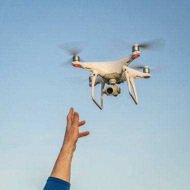 Carr, CO, ABD - 12 Nisan 2017: DJI Phantom 4 Pro Quadcopter İHA 'sının fırlatılması veya yakalanması - operatör el ve İHA' nın gökyüzüne karşı uçması.