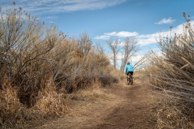 Kışın tek bir patika ya da sonbahar manzarası çakıl bisikletli bir erkek bisikletçiyle - Arapaho Bend Doğal Alanı Fort Collins, Colorado