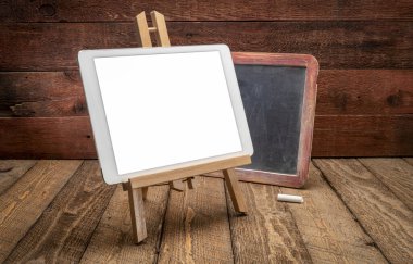 Boş bir izole ekran (kırpma yolu dahil) ile dijital tablet modeliyle eski tahta tahtası ile rustik, yıpranmış ahşap zemin karşı