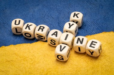 Ukrayna ve Kyiv harf küpleriyle Ukrayna ulusal bayrağının mavi ve sarı renkleri ile soyut kağıt parçalarına karşı