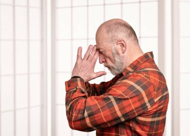 Son sınıf öğrencisi parmaklarını üçüncü göz noktasına bastırarak aküpres terapisi uyguluyor. Kendi kendine bakım kavramı.