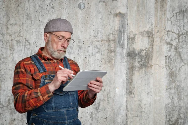 Zelfverzekerde Senior Man Met Bril Flanellen Hemd Overall Maakt Aantekeningen — Stockfoto