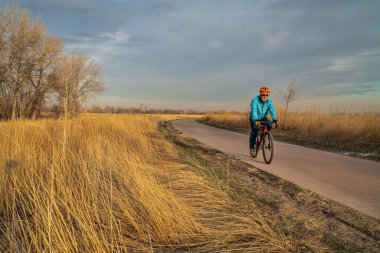 Fort Collins, Colorado 'daki Poudre River Trail' de çakıl bisikleti süren yaşlı bir bisikletçiyle bisiklet parkında.