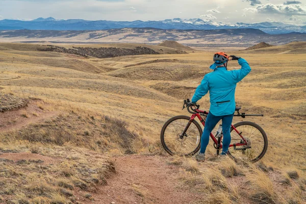 Colorado eteklerinde tek bir patika üzerinde çakıllı bisikletli erkek bisikletçi ilkbahar manzarası, Soapstone Çayır Doğal Alanı