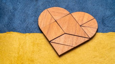 Ukrayna ulusal bayrağının renkleriyle soyut kağıt üzerine kalp tangramı - mavi ve sarı, Ukrayna kavramını destekliyor