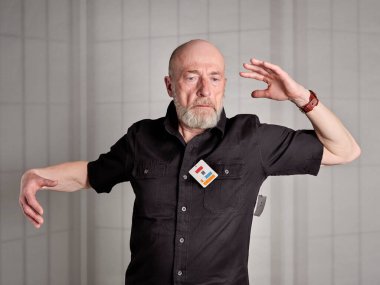 Yaşlı, kel ve sakallı adam üzerinde fiyat etiketi olan yeni bir gömlek deniyor.