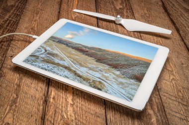 Kuzey Colorado 'daki Rocky Dağları' nın eteklerinde gün batımı, sonbahar ya da kış manzarası dijital tablet üzerindeki bir hava görüntüsünü inceliyor.