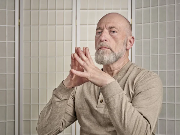 Kafası ve omuzları kel ve sakallı yaşlı adamın portresi ellerini uzatıyor