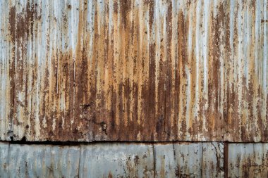 grunge urban or industrial background and texture, building wall covered by weathered, rusty, corrugate metal sheets