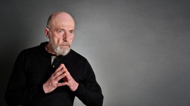 Kendine güvenen, ciddi ve odaklanmış yaşlı bir adamın portresi.