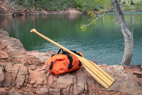 位于科罗拉多北部高山湖岸岩石上的木制独木舟桨和防水消声器 马牙水库 — 图库照片