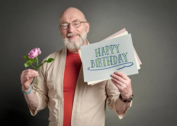 Χρόνια Πολλά Χαμογελαστός Ηλικιωμένος Άνδρας Ροζ Τριαντάφυλλο Και Ευχετήρια Κάρτα — Φωτογραφία Αρχείου