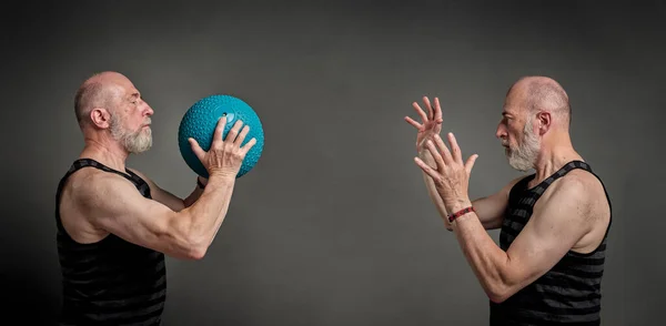 double portrait of a athletic senior man (in late 60s) exercising with a heavy slam or medicine  ball, activity and fitness over 60 concept