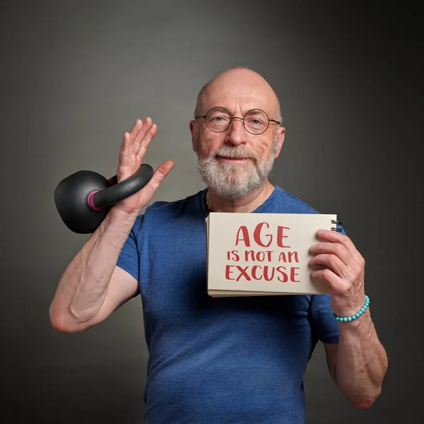 Senior Man Late 60S Exercising Iron Kettlebell Holding Inspirational Notebook — Stok fotoğraf