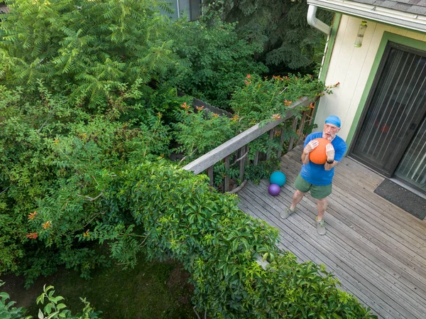 Senior Man Exercising Heavy Slam Ball His Backyard Patio Summer — Φωτογραφία Αρχείου