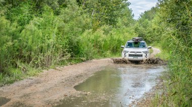 Overton, Mo, Amerika Birleşik Devletleri - 13 Ağustos 2017: Toyota 4runner Suv (2016 iz edition) paddleboard kadar bir stand taşıyan yönlendirdiğini su su birikintileri bir kir backcountry yolda büyük çamurlu Ulusal balık ve yaban hayatı Sığınağı.