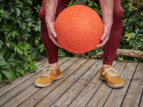 Male Compression Pants Exercising Heavy Slam Ball Backyard Deck Functional — стоковое фото