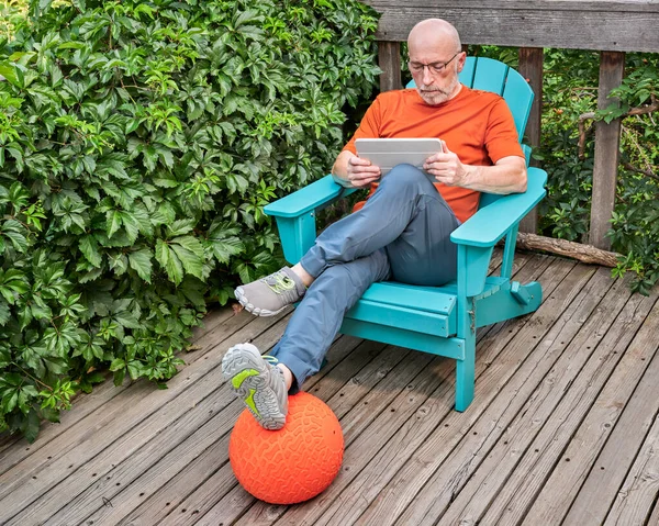 Senior Man Digital Tablet Relaxing Adirondack Chair Wooden Backyard Deck — Stockfoto