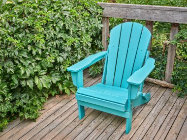 empty Adirondack chair on a wooden backyard deck, summer scenery in COlorado