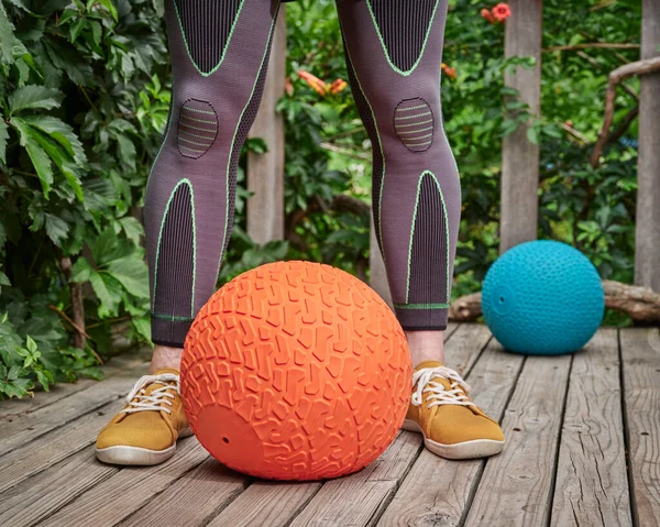 Male Wearing Compression Sleeves Exercising Heavy Slam Ball Backyard Deck — Stockfoto