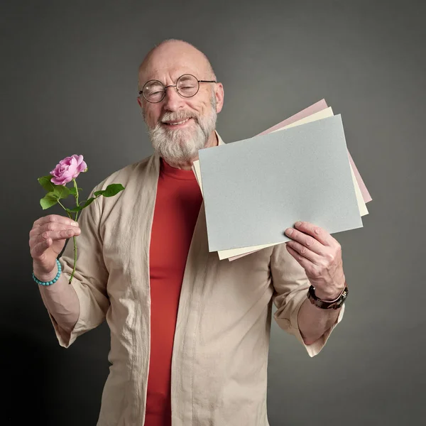 Χαμογελαστός Ηλικιωμένος Ροζ Τριαντάφυλλο Και Ένα Λευκό Φύλλο Χαρτί — Φωτογραφία Αρχείου