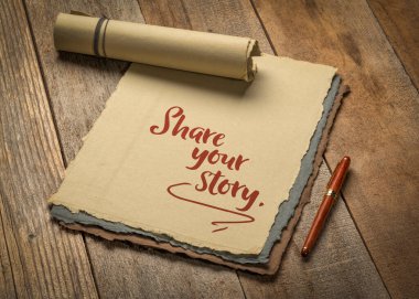 share your story - inspirational handwriting on a deckle edge paper with a stylish pen against rustic wood
