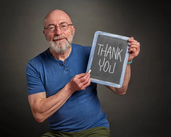 thank you sign - senior man with a slate blackboard and white chalk communication concept