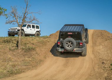 Loveland, CO, USA - August 27, 2022: Jeep Wranglers on a training drive off-road course approaching a steep hill.
