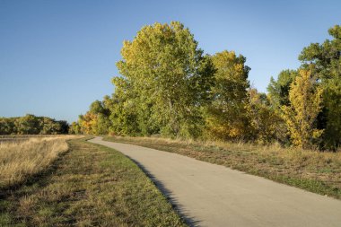 Fort Collins bölgesindeki Poudre Nehri boyunca asfalt bisiklet yolu, sonbahar manzarası, dinlenme ve gidiş-dönüş konsepti