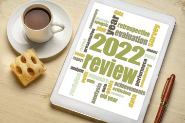 2022 yılı dijital tablette kelime bulutu, bir fincan kahveyle düzlük, yıl sonu iş analizi konsepti