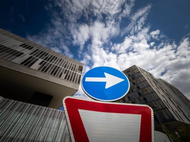 Çağdaş bir kentsel alanda bir yol işareti üzerinde yön oku