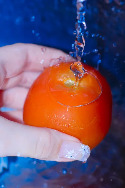 Čerstvé červené rajče mytí pod tekoucí vodou.... — Stock fotografie