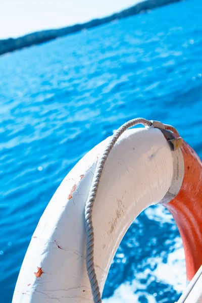 Белый спасательный буй на заборе лодки — стоковое фото