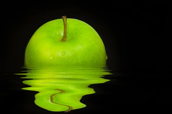 Fresh green apple on black background with water reflection — Stock Photo, Image