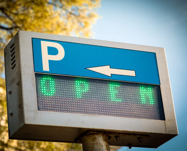 Abierto... signo de aparcamiento en frente de un estacionamiento — Foto de Stock