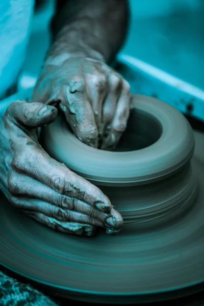 Καλλιτεχνική τονισμένα χέρια που εργάζονται στον τροχό αγγειοπλαστικής, — Φωτογραφία Αρχείου