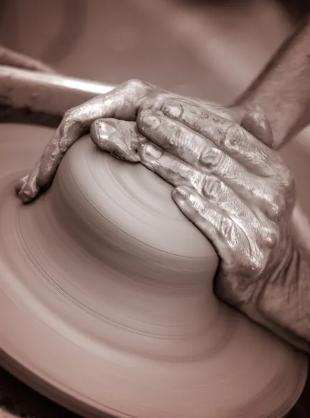 Manos trabajando sobre rueda de cerámica, artística tonificada —  Fotos de Stock