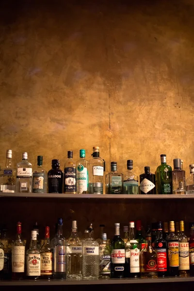 Полки бара полные бутылок алкогольных напитков — стоковое фото