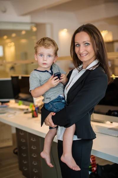 Businesswoman with small child in the office