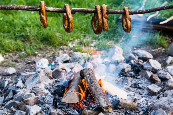 Gernan brezels on a stick over fire — Stock Photo, Image