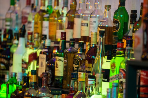 Alcoholic beverages in bottles at a bar.