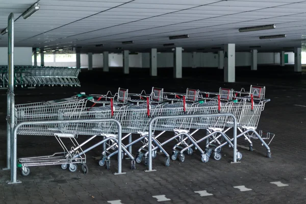 Fileiras de carrinhos de compras no parque de estacionamento abandonado — Fotografia de Stock