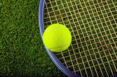 Tenis top ve raket çimenlerin üzerinde