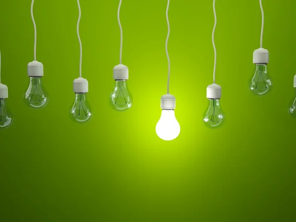 Reihe von Glühbirnen auf grünem Hintergrund — Stockfoto